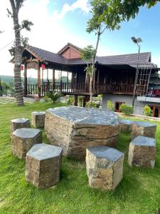 a group of stone stools in front of a building at Highland garden - homestay Phú Yên 