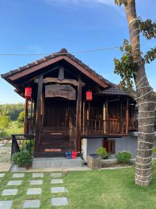 a building with a palm tree in front of it at Highland garden - homestay Phú Yên 