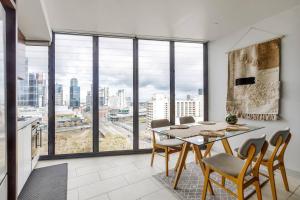 comedor con mesa y sillas y ventana grande en On the Banks of the Yarra - Best of Melbourne Living, en Melbourne