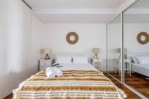 1 dormitorio blanco con 1 cama grande y espejos en On the Banks of the Yarra - Best of Melbourne Living, en Melbourne