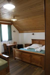 a bedroom with a large bed with a wooden ceiling at Šport center Prodnik in Ljubno