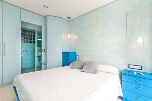 a bedroom with a white bed and a blue dresser at Super Beach 2 in Platja  d'Aro