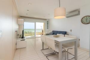a kitchen and dining room with a white table and chairs at Super Beach 2 in Platja  d'Aro