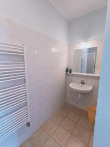 a white bathroom with a sink and a mirror at Cozy Room with garden in Bratislava in Bratislava