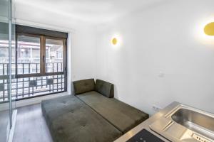 un sofá en una habitación con lavabo y ventana en AngelitoMAD, en Madrid