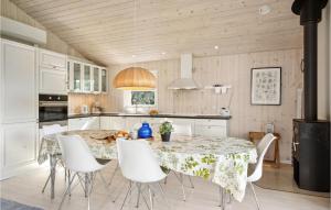 een keuken met een tafel en witte stoelen bij Cozy Home In Otterup With Kitchen in Otterup