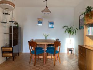 een eetkamer met een houten tafel en stoelen bij Via Funghi, po prostu dom in Warschau