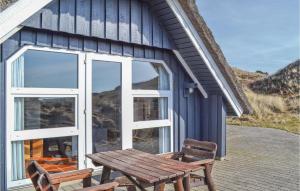 HavrvigにあるNice Home In Hvide Sande With 2 Bedrooms And Saunaの青い建物の外に座る木製のベンチ
