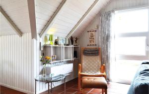 HavrvigにあるNice Home In Hvide Sande With 2 Bedrooms And Saunaのリビングルーム(テーブル、椅子付)
