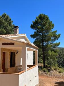 a small white house with a tree in the background at El Quejigo in Molinicos