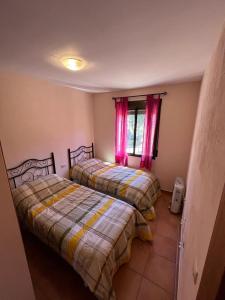 a bedroom with two beds and a window at El Quejigo in Molinicos