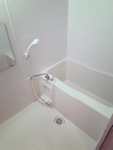 eine Badewanne mit Dusche im Bad in der Unterkunft Brand New Shinjuku Station 5 Mins - Apartment D in Tokio