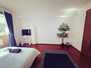a bedroom with a bed and a potted plant at Brand New Shinjuku Station 5 Mins - Apartment D in Tokyo