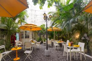 a restaurant with tables and chairs and umbrellas at Stay Banaras - A Boutique Hotel in Sigra in Varanasi