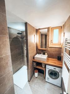 een badkamer met een wastafel en een wasmachine bij Le Peyra, Apt 4 personnes avec terrasse et jardin in Le Monêtier-les-Bains