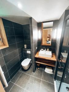 een badkamer met een wit toilet en een wastafel bij Le Peyra, Apt 4 personnes avec terrasse et jardin in Le Monêtier-les-Bains