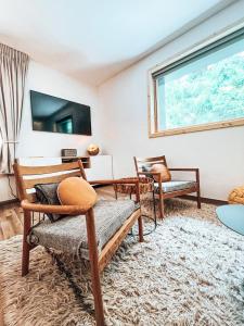 een woonkamer met houten meubels en een groot raam bij Le Peyra, Apt 4 personnes avec terrasse et jardin in Le Monêtier-les-Bains