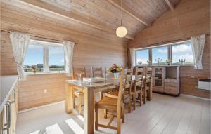 ein Esszimmer mit Holzwänden sowie einem Tisch und Stühlen in der Unterkunft Lovely Home In Ulfborg With House Sea View in Ulfborg