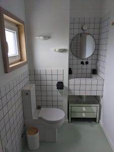 ein weißes Bad mit einem WC und einem Spiegel in der Unterkunft Modern and spacious Cork House with private valley view in Caldas da Rainha