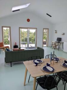 ein Wohnzimmer mit Tischen und einer grünen Couch in der Unterkunft Modern and spacious Cork House with private valley view in Caldas da Rainha