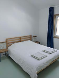 1 dormitorio con 1 cama con 2 toallas en Modern and spacious Cork House with private valley view, en Caldas da Rainha