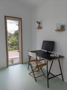 a desk with a computer and a chair in front of a window at Modern and spacious Cork House with private valley view in Caldas da Rainha