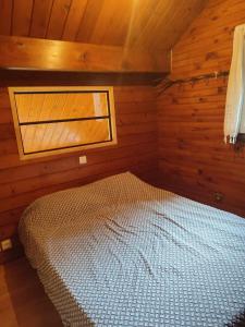 a bedroom with a bed in a wooden cabin at haut de chalet le Bois de Cerf in Les Angles