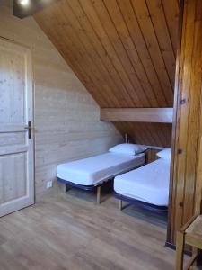 two beds in a room with a wooden ceiling at haut de chalet le Bois de Cerf in Les Angles