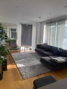 a living room with a couch and a rug at Luxurious NEW 2 Bed apartment in London