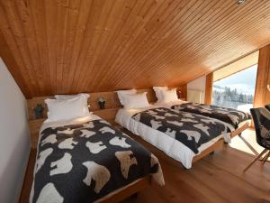 two beds in a room with a window at Chalet Le Grand-Bornand, 6 pièces, 11 personnes - FR-1-467-68 in Le Grand-Bornand
