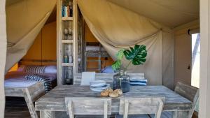 a table in a tent with a plant on it at Camping le Moulin des Oies in Belz