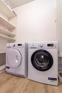 a washing machine and a dryer in a laundry room at Résidence pieds des pistes in Ax-les-Thermes
