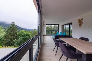 een eetkamer met een tafel en stoelen en een groot raam bij Résidence pieds des pistes in Ax-les-Thermes