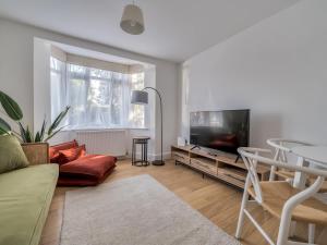 a living room with a couch and a tv and a table at Pass the Keys Stylish 2 Bed Apartment Parking Oxford in Oxford