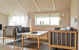 HavrvigにあるNice Home In Hvide Sande With 4 Bedrooms, Sauna And Wifiのリビングルーム(ソファ、テーブル付)