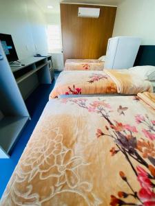 a hotel room with two beds with flowers on them at LOFT PRÓXIMO AO FORUM in Chapecó
