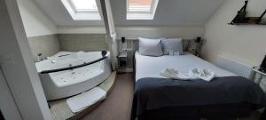een slaapkamer met een bad en een bed met handdoeken bij Hotel Heere in Raamsdonksveer