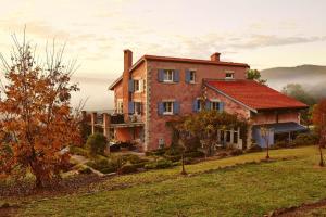 ein altes Haus auf einem Hügel mit dem Ozean im Hintergrund in der Unterkunft Talits Estate Vineyard in Broke