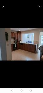 uma grande cozinha com armários de madeira e uma bancada em Cobh Rambler em Cobh
