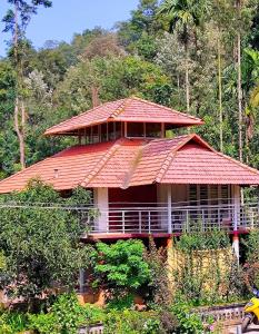 a house with an orange roof in the forest at Coorg devine spark in Madikeri
