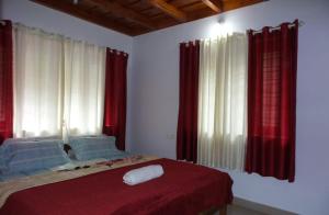 a bedroom with red and white curtains and a bed at Coorg devine spark in Madikeri