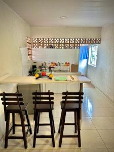 a kitchen with three chairs and a counter with a island at Apartamento sector aeropuerto in Manizales