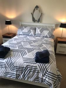 a white bed with black and white sheets and pillows at Kesh Lakeside Cottage in Kesh