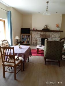 a living room with a table and chairs and a fireplace at Nire Valley Cottage 
