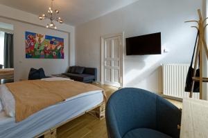 a bedroom with a bed and a couch and a tv at Apartment near Warschauer Platz and Spree river in Berlin