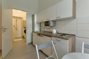 a kitchen with white cabinets and a counter top at Apartment near Warschauer Platz and Spree river in Berlin