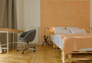 a bedroom with a bed and a desk and a chair at Apartment near Warschauer Platz and Spree river in Berlin