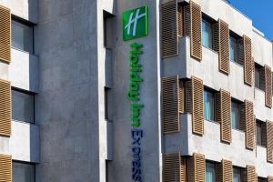 un edificio con una señal verde en el costado. en Holiday Inn Express Porto City Centre, an IHG Hotel en Oporto