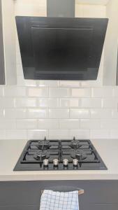 a stove top oven with a flat screen tv above it at Modern holiday let in Skipton, North Yorkshire in Skipton