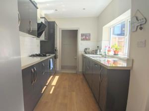 a kitchen with stainless steel appliances and a wooden floor at Modern holiday let in Skipton, North Yorkshire in Skipton